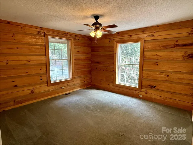 a view of empty room with window and ceiling fan
