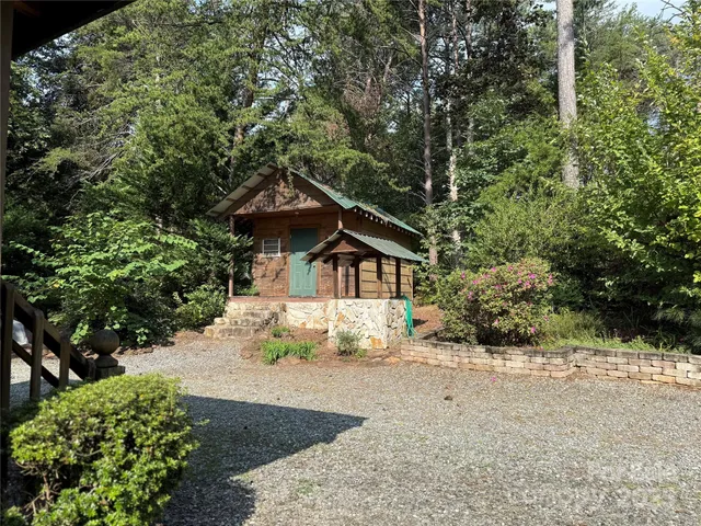 a view of a house with a small yard plants and large tree
