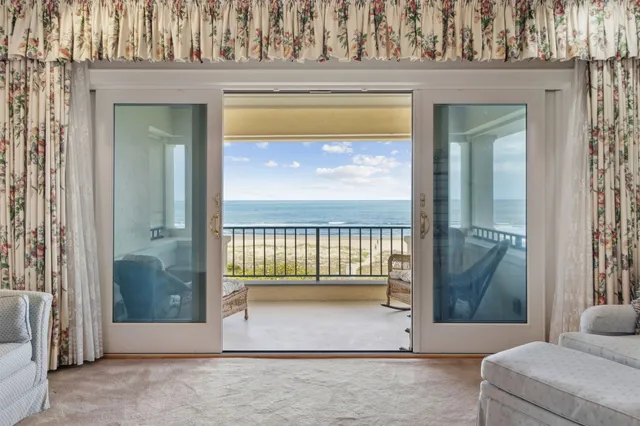 a living room with furniture and a floor to ceiling window