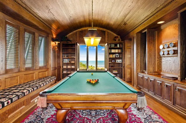 a view of a dining room with furniture a chandelier and large windows