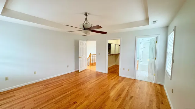 an empty room with windows closet and chandelier fan