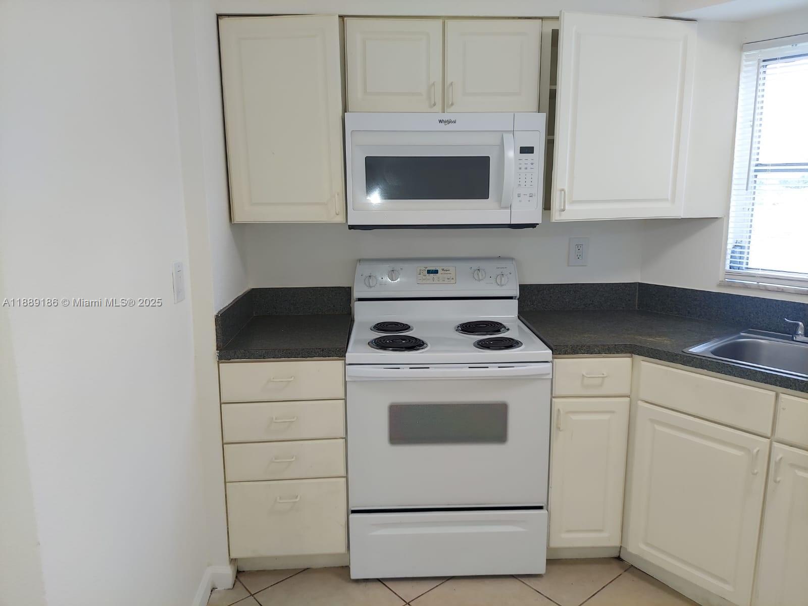 978 Southwest 10th Drive, Unit 9 Pompano Beach, FL 33060 - Photo 12 of 13 a white stove top oven sitting inside of a kitchen