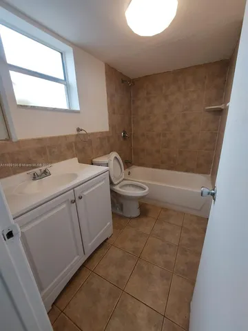 a bathroom with a toilet a sink a mirror and a bathtub