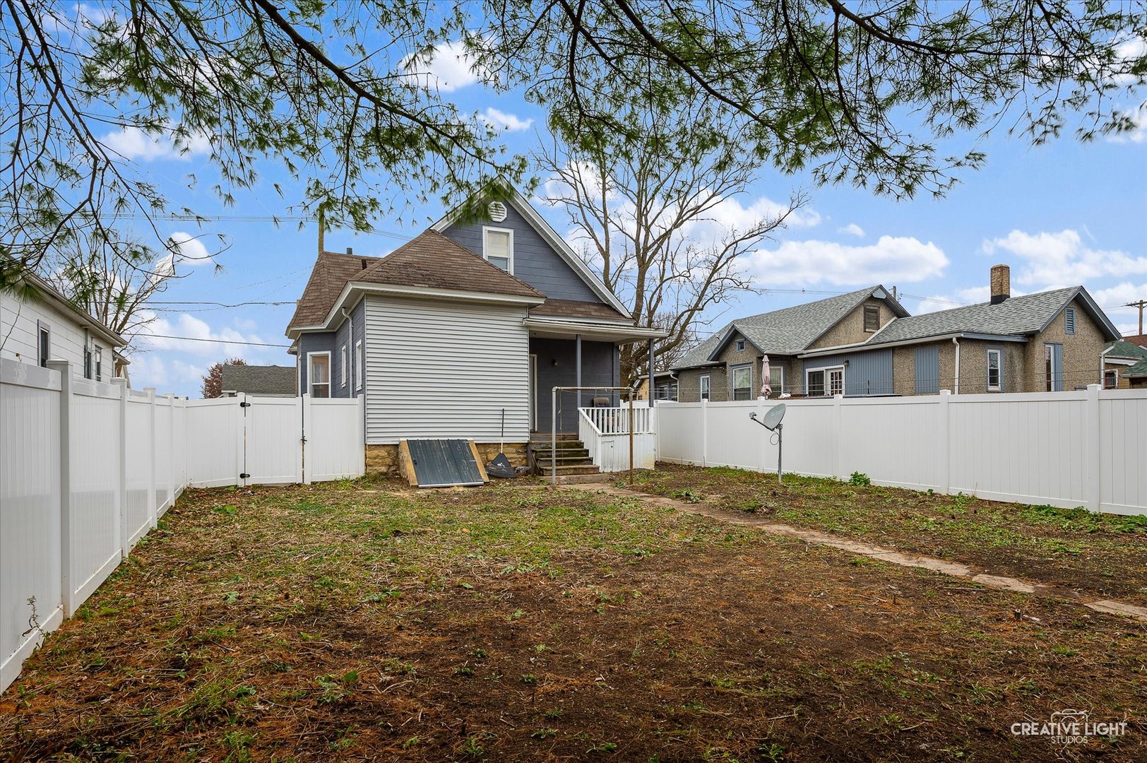 1409 Pulaski Street Peru, IL 61354 - Photo 17 of 20 a white house that has a tree in front of it