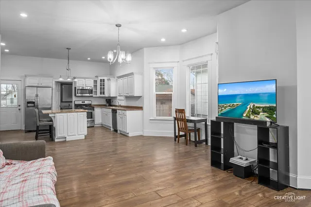 a open kitchen with stainless steel appliances granite countertop a refrigerator dining table and chairs