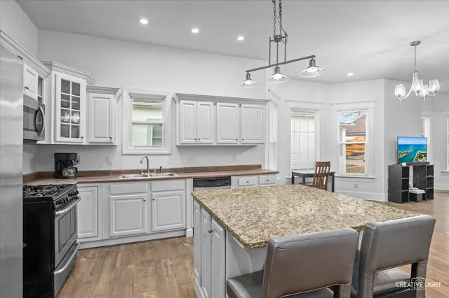 a kitchen with kitchen island granite countertop a sink and stove