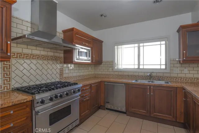 a kitchen with stainless steel appliances a stove sink and cabinets