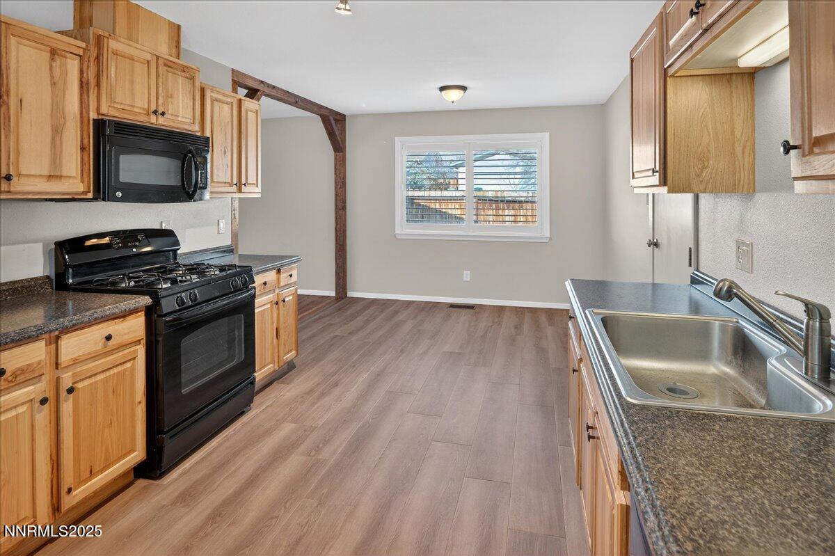 1495 Doric Drive Reno, NV 89503 - Photo 16 of 42 a kitchen with granite countertop a sink a stove top oven and cabinetry