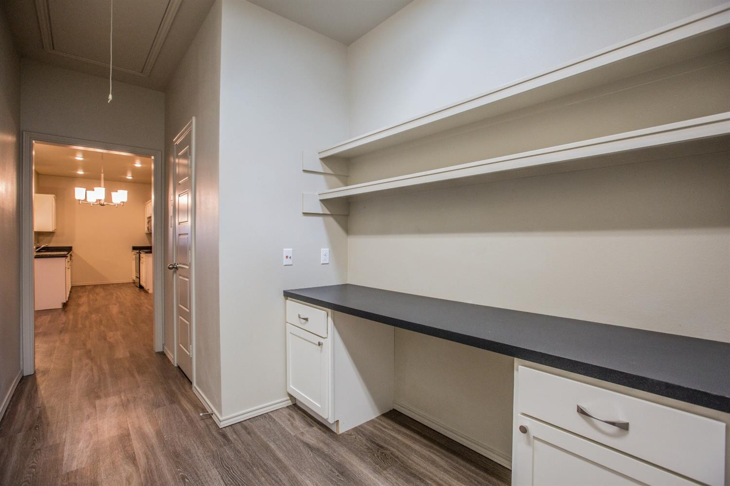 2123 10th Street Lubbock, TX 79401 - Photo 12 of 14 a kitchen with a refrigerator and a wooden floor