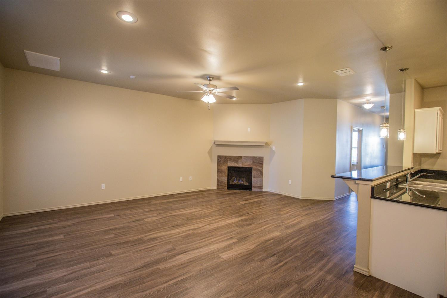 2123 10th Street Lubbock, TX 79401 - Photo 2 of 14 a view of an empty room with wooden floor and a fireplace