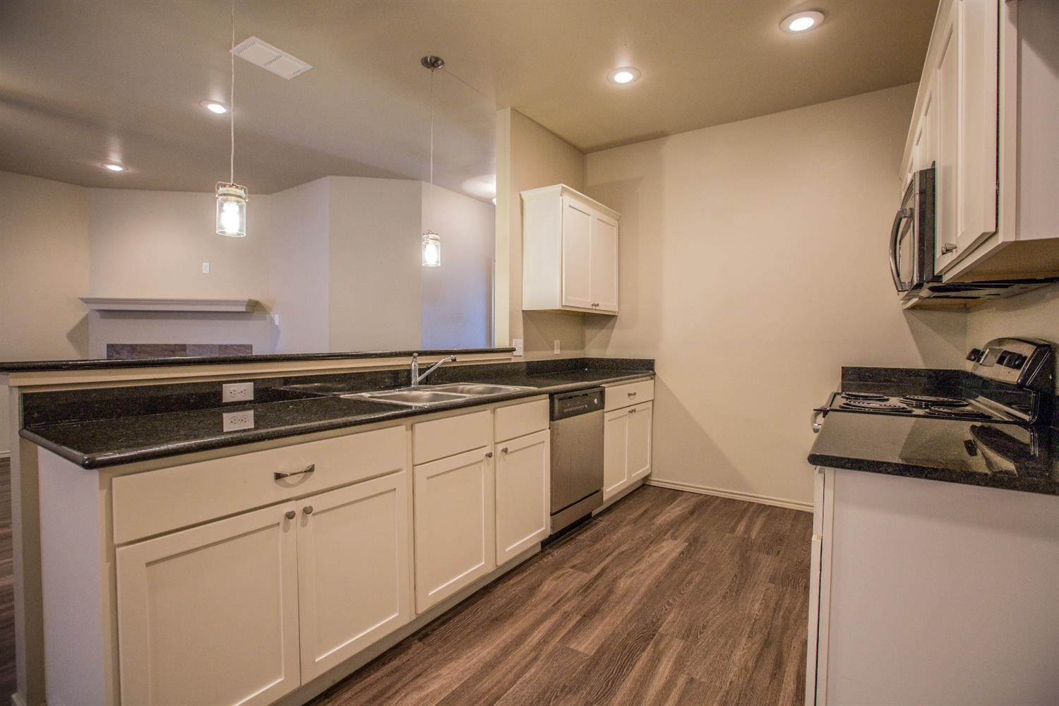 2123 10th Street Lubbock, TX 79401 - Photo 4 of 14 a kitchen with granite countertop a sink and a stove top oven