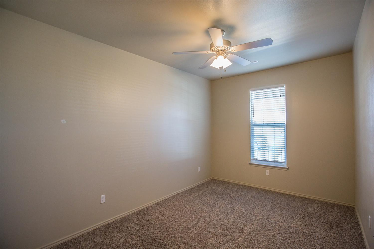 2123 10th Street Lubbock, TX 79401 - Photo 6 of 14 an empty room with windows and fan