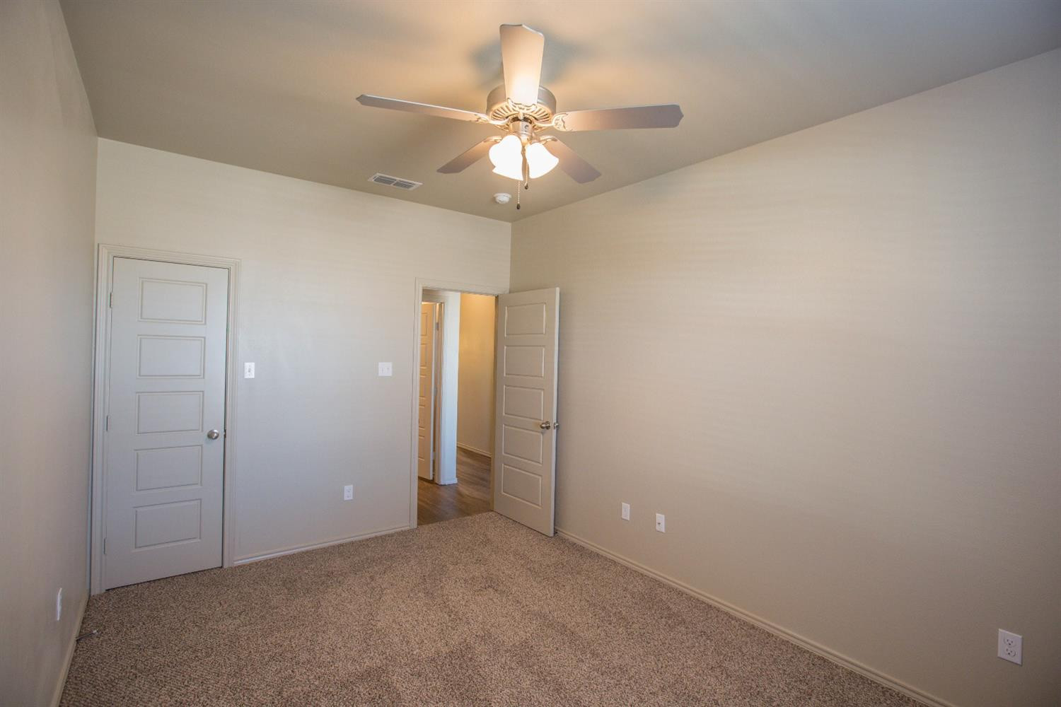 2123 10th Street Lubbock, TX 79401 - Photo 7 of 14 an empty room with a ceiling fan and a window