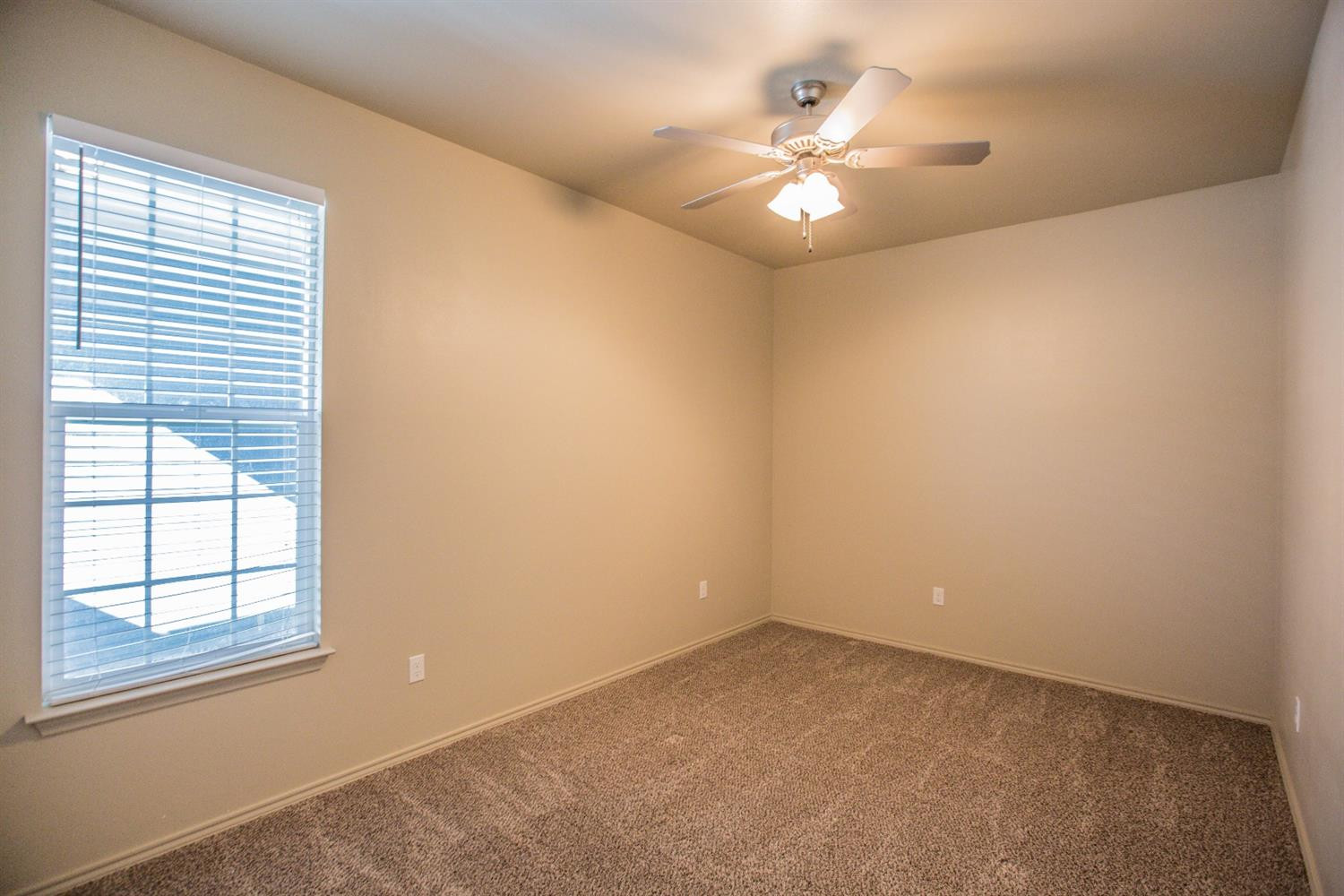 2123 10th Street Lubbock, TX 79401 - Photo 9 of 14 an empty room with windows and chandelier fan