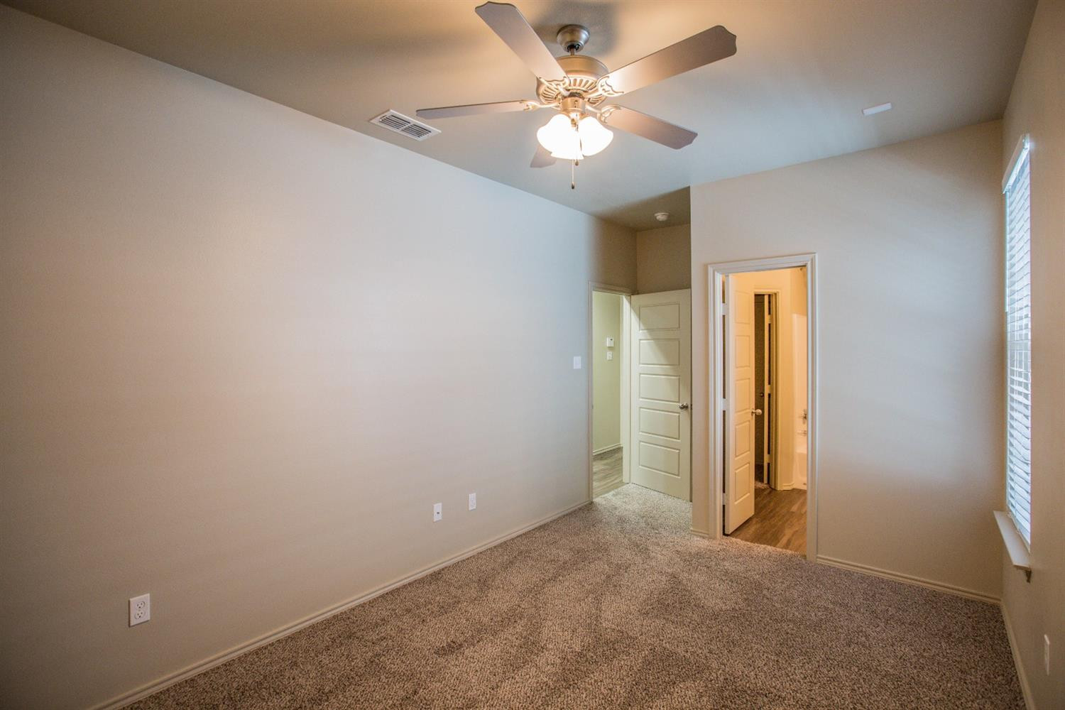 2123 10th Street Lubbock, TX 79401 - Photo 10 of 14 an empty room with a ceiling fan and a window