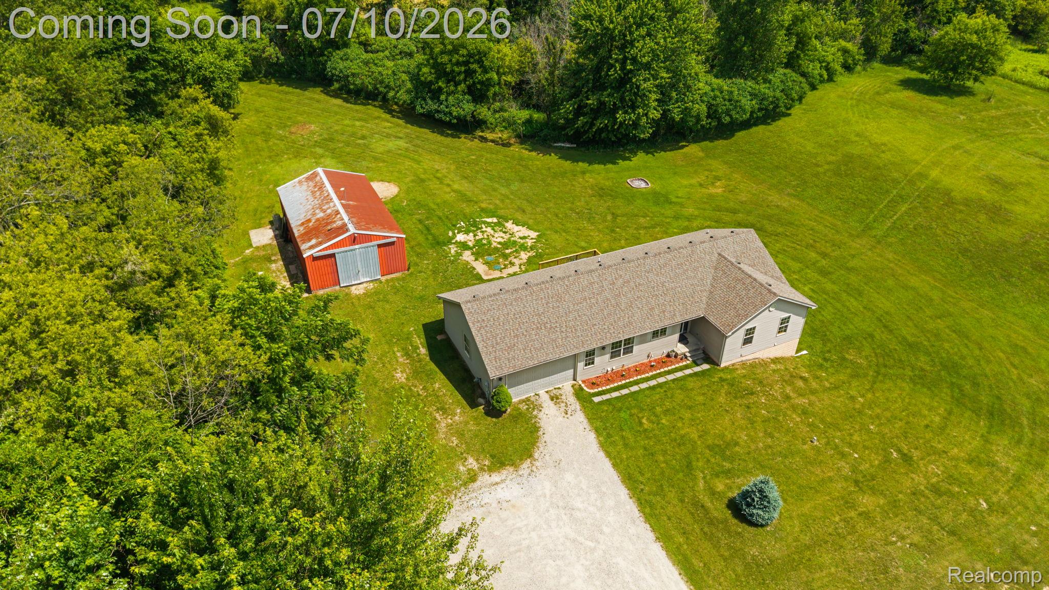 3144 North Nicholson Road Fowlerville, MI 48836 - Photo 4 of 70 Aerial perspective showcasing a single-story residence with a light gray exterior and a shingle roof