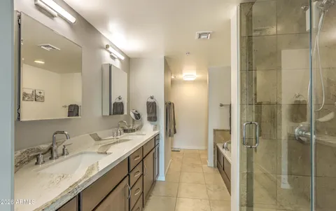 a en suite bathroom with a double vanity sink and a mirror