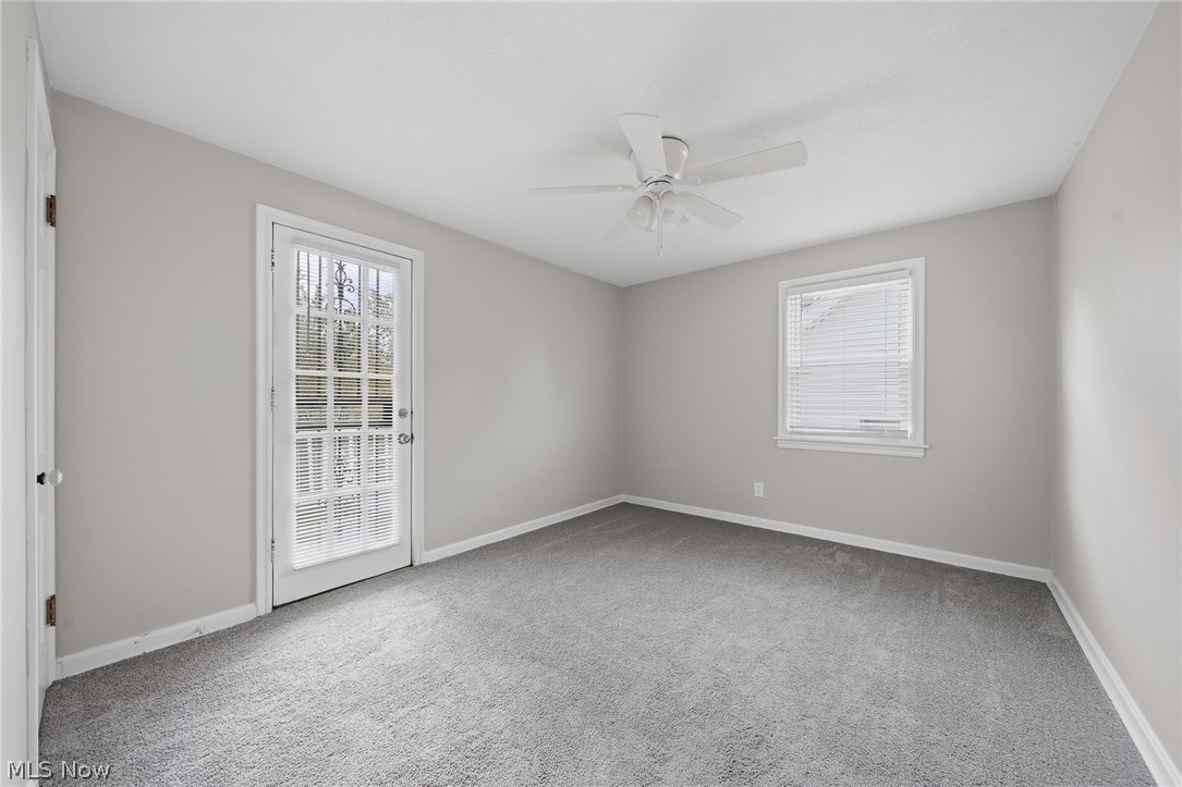 2231 Brockway Road University Heights, OH 44118 - Photo 17 of 46 Room featuring neutral wall paint, gray carpet flooring, a ceiling fan, a window with blinds, and a glass-paneled exterior door that leads to your balcony.