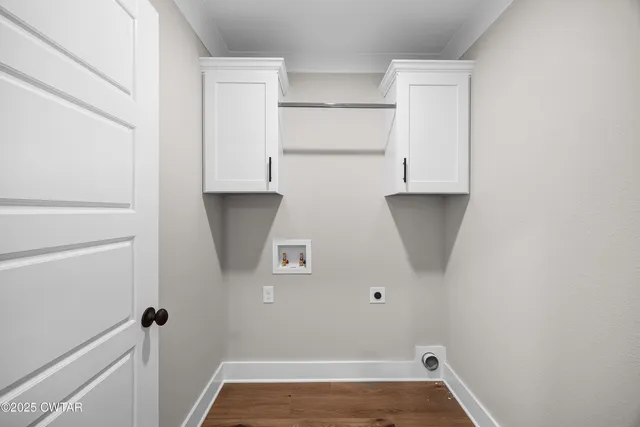 an empty room with wooden floor chandelier and windows
