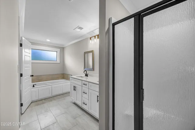 an empty room with windows and ceiling fan