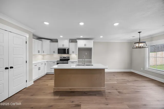 a view of a livingroom with wooden floor and a ceiling fan