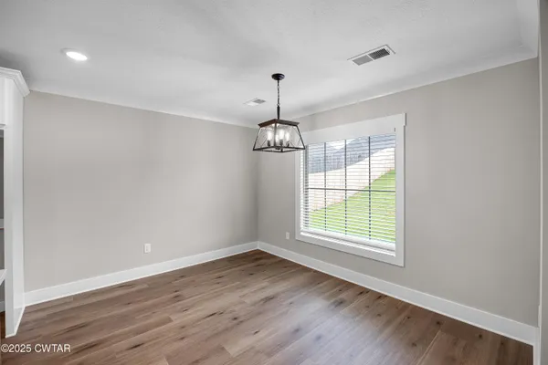 a kitchen that has a stove a sink and a wooden floor with wooden floor