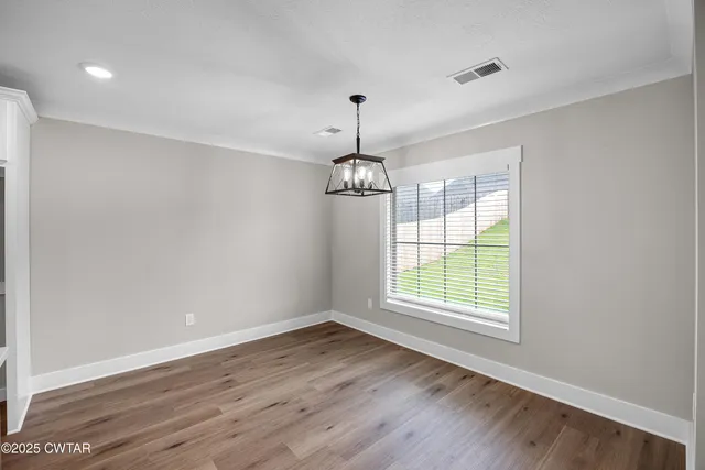 a kitchen that has a stove a sink and a wooden floor with wooden floor