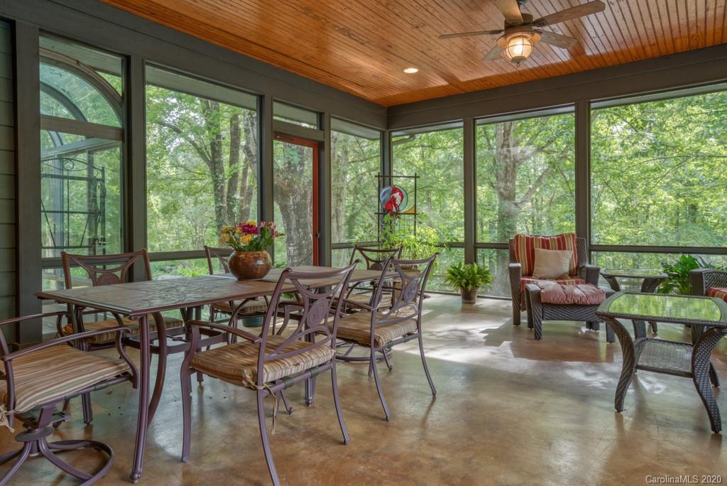 305 Misty Hill Road Columbus, NC 28722 - Photo 15 of 46 a view of a dining room with furniture large windows and wooden floor