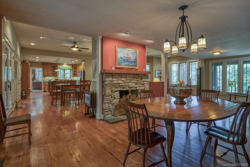 305 Misty Hill Road Columbus, NC 28722 - Photo 17 of 46 a dining room with wooden floor a chandelier a wooden table and chairs
