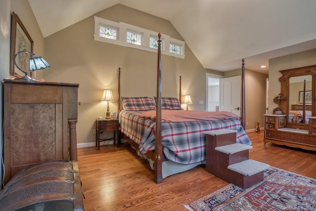 305 Misty Hill Road Columbus, NC 28722 - Photo 28 of 46 a bedroom with a bed a mirror and lamp