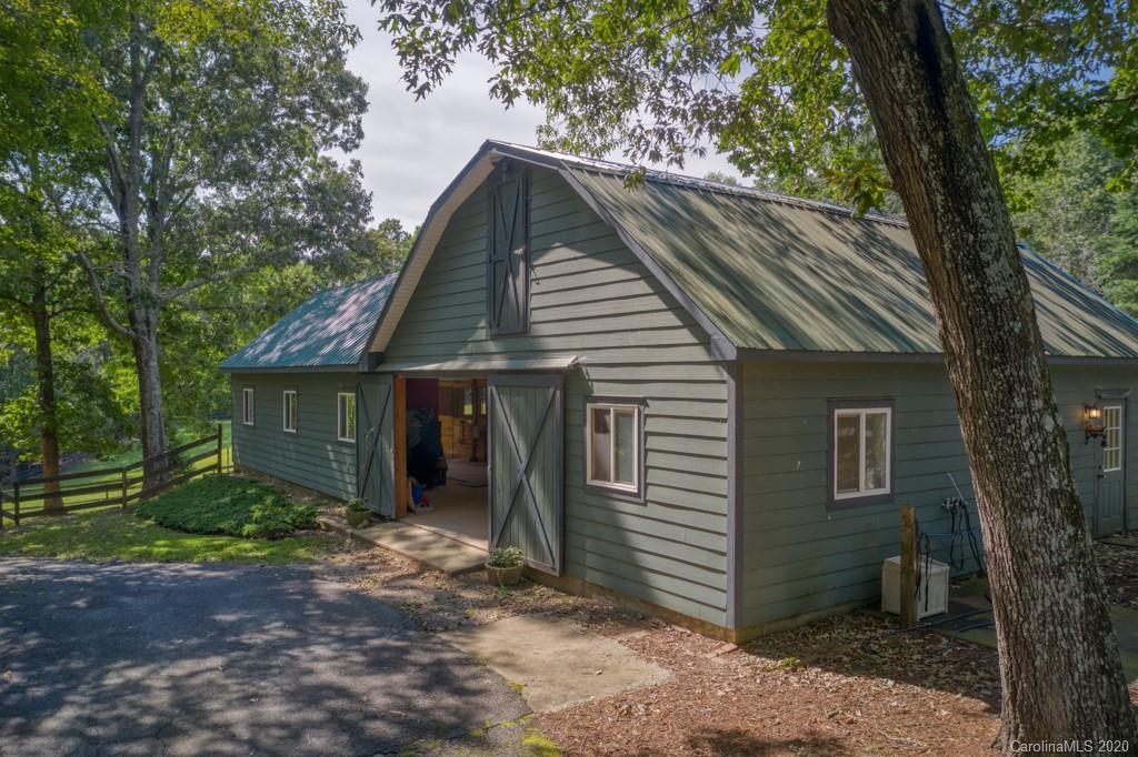 305 Misty Hill Road Columbus, NC 28722 - Photo 42 of 46 a view of a house with a yard plants and large tree