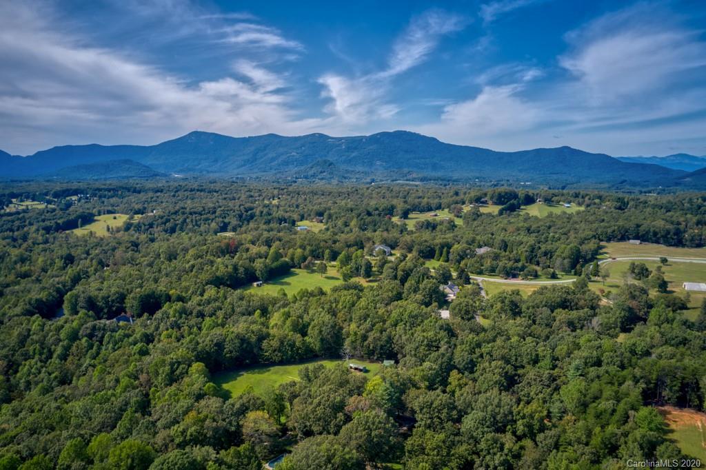 305 Misty Hill Road Columbus, NC 28722 - Photo 43 of 46 a view of a lush green hillside and a houses
