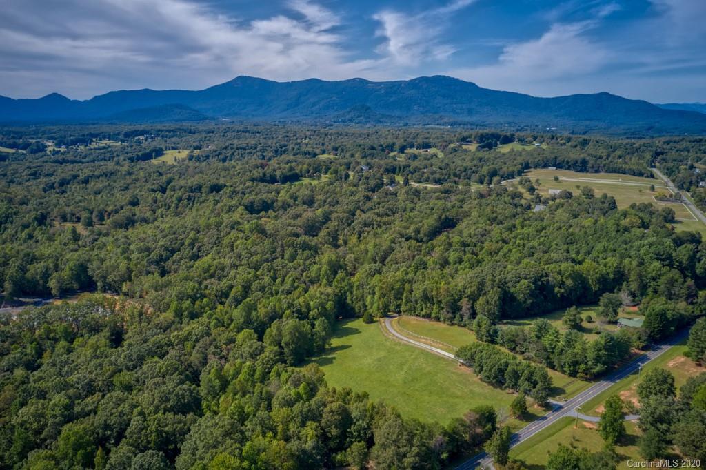 305 Misty Hill Road Columbus, NC 28722 - Photo 44 of 46 a view of a lush green hillside and a houses