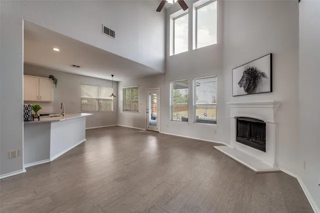 a view of a livingroom with wooden floor and a kitchen