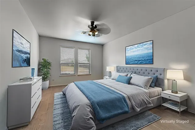 a bedroom with a large bed couch and windows