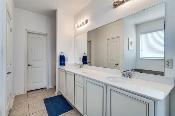 a en suite bathroom with a double vanity sink and a mirror