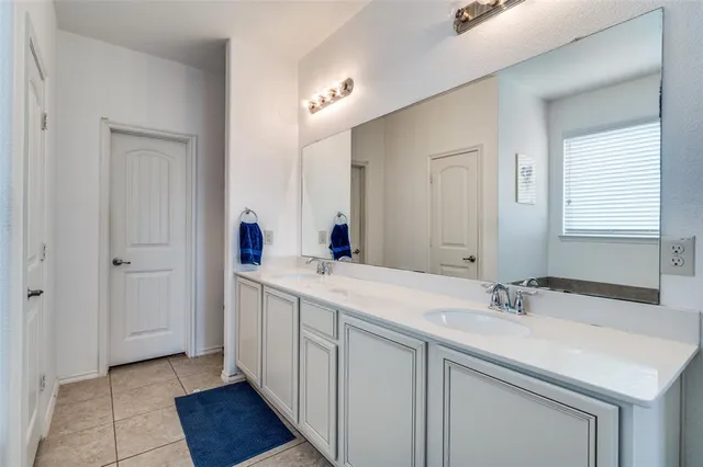 a en suite bathroom with a double vanity sink and a mirror