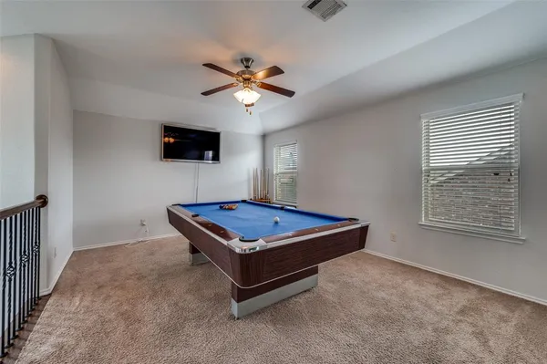 a living room with pool table and a flat screen tv