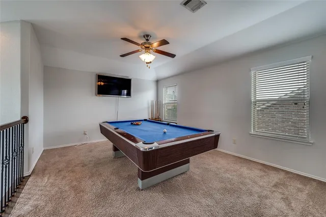 a living room with pool table and a flat screen tv