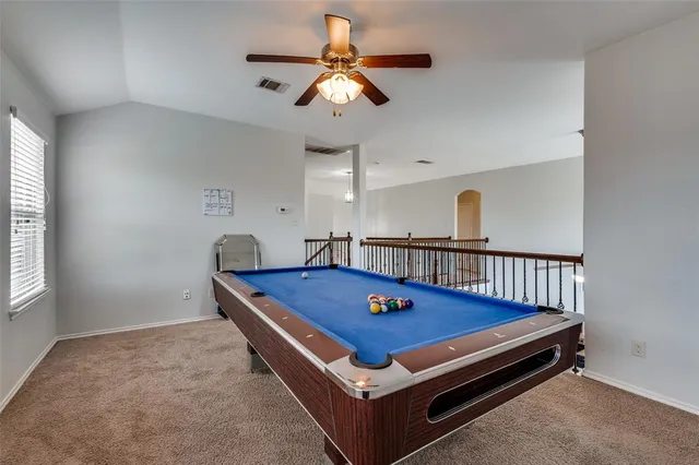 a room with pool table and windows