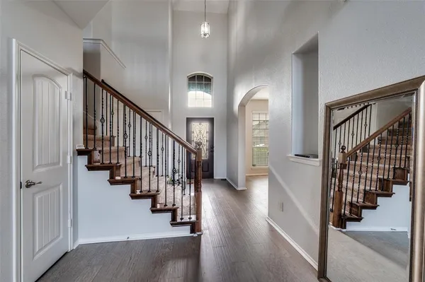 a view of a hallway with wooden floor and stairs