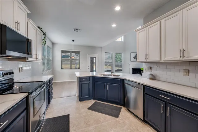 a kitchen with stainless steel appliances granite countertop a sink stove microwave and refrigerator
