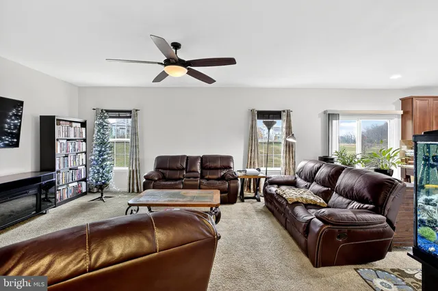 a kitchen with stainless steel appliances kitchen island granite countertop a table chairs and a refrigerator