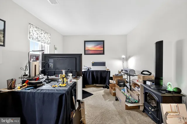 a view of a workspace with furniture and a window