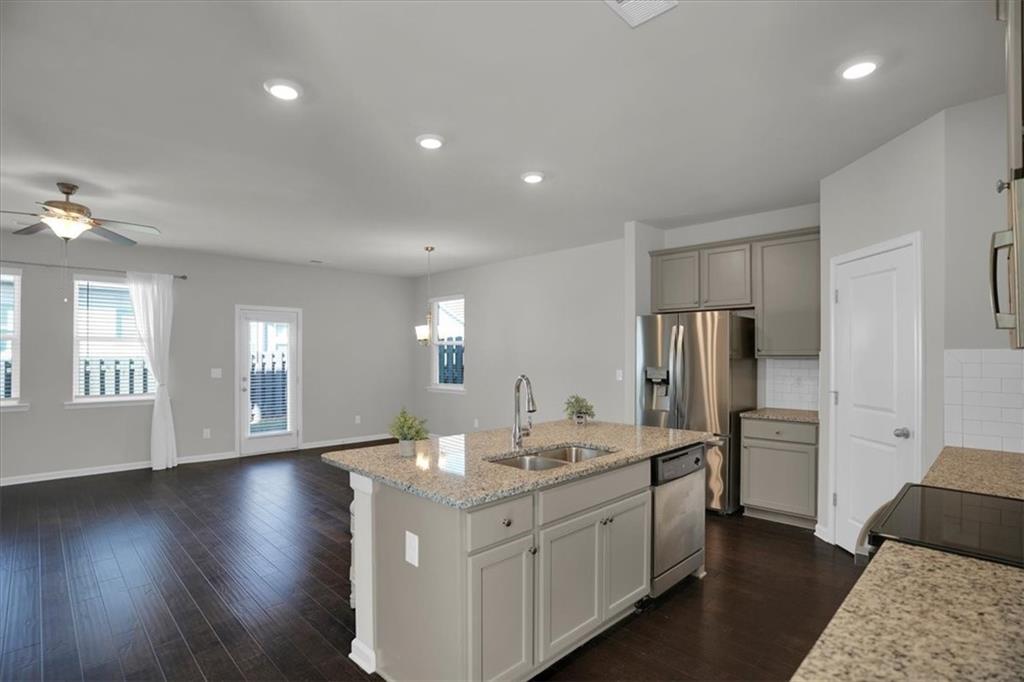 1506 Ashbrooke Trace Stone Mountain, GA 30083 - Photo 20 of 54 a kitchen with white cabinets and stainless steel appliances