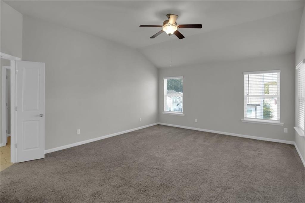 1506 Ashbrooke Trace Stone Mountain, GA 30083 - Photo 25 of 54 an empty room with a window and a ceiling fan