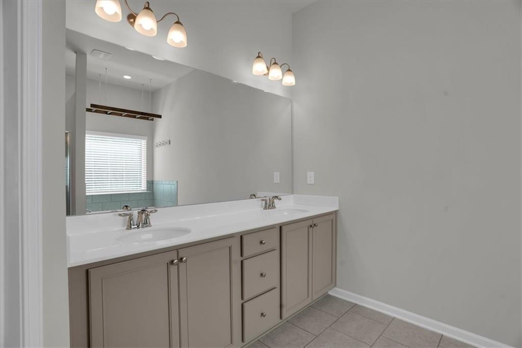 1506 Ashbrooke Trace Stone Mountain, GA 30083 - Photo 26 of 54 a bathroom with a sink a light fixture and a mirror