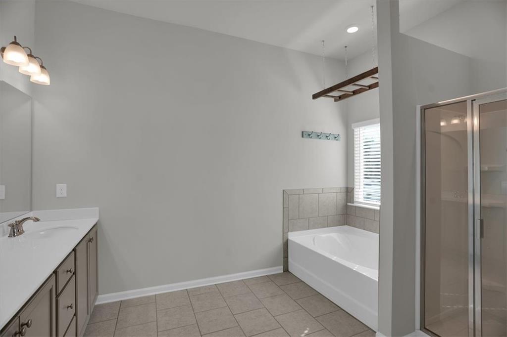 1506 Ashbrooke Trace Stone Mountain, GA 30083 - Photo 30 of 54 a bathroom with a tub shower vanity and a sink