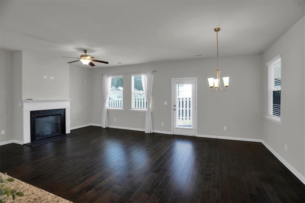 1506 Ashbrooke Trace Stone Mountain, GA 30083 - Photo 7 of 54 a view of an empty room with wooden floor fireplace and a window