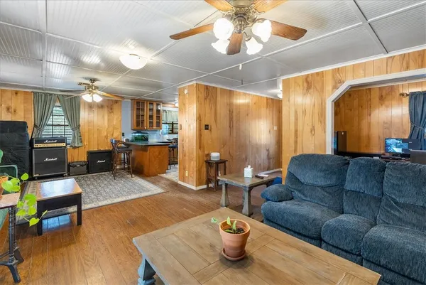 a kitchen with stainless steel appliances kitchen island granite countertop a refrigerator a stove a sink dishwasher and a dining table with wooden floor